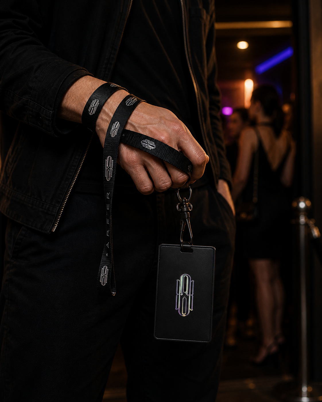 Lanyard Noir wrapped around the wrist with a black pass holder at a late-night event