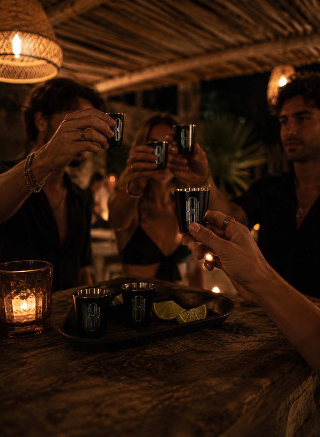 Friends toasting with the Vaso Shot at a candlelit night bar